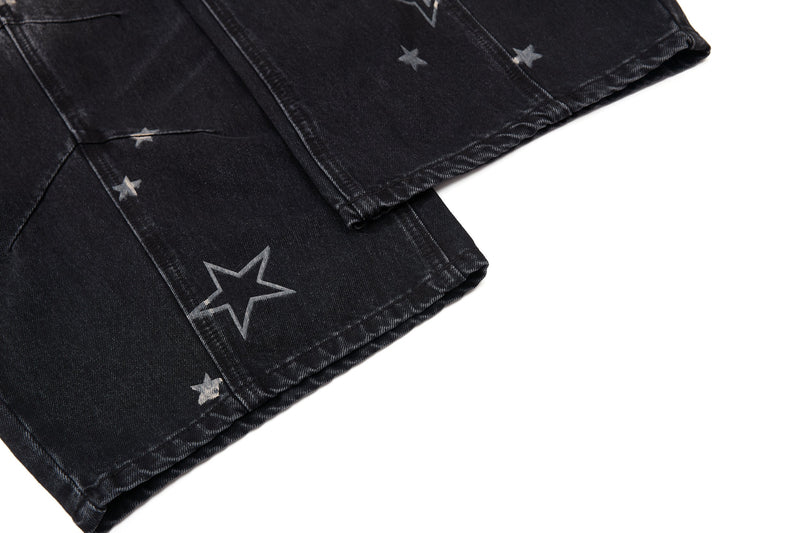 Close-up of lower pant leg hem with star print on black denim