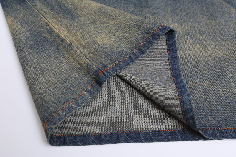 Close-up of a vintage denim jersey tee hem with contrast orange stitching and folded blue fabric detail