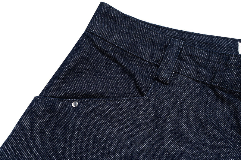 Close-up of the front waistband and left hip seam on dark indigo denim shorts