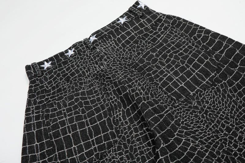 Close-up of black pants waistband and front pleats with star trim