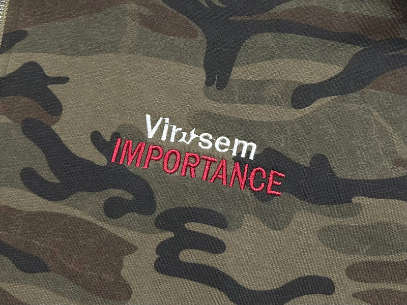 Close-up of Virvsem Importance chest embroidery on camo hoodie