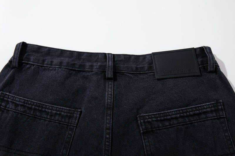 Close-up of the back waistband on washed black jeans with black logo patch