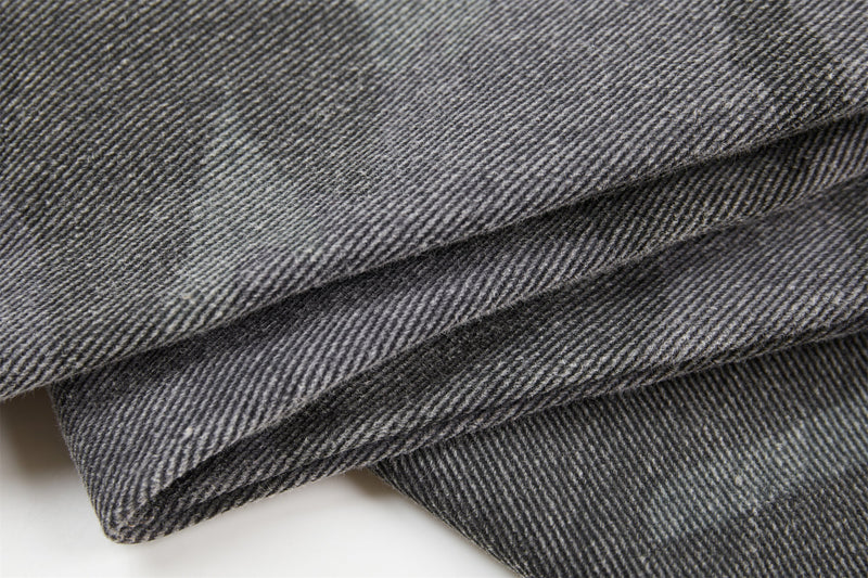 Close-up of gray denim fabric texture with diagonal twill weave