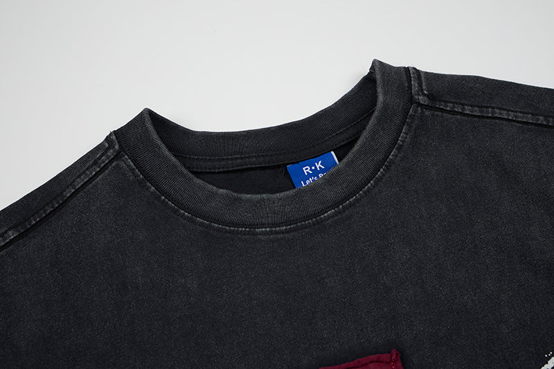 Black distressed sleeveless T-shirt with faded gothic cross graphic and ribbed crew neckline, close-up detail
