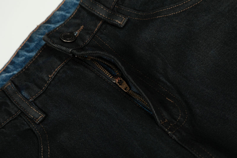 Close-up of black denim front fly with zipper and button at the waistband