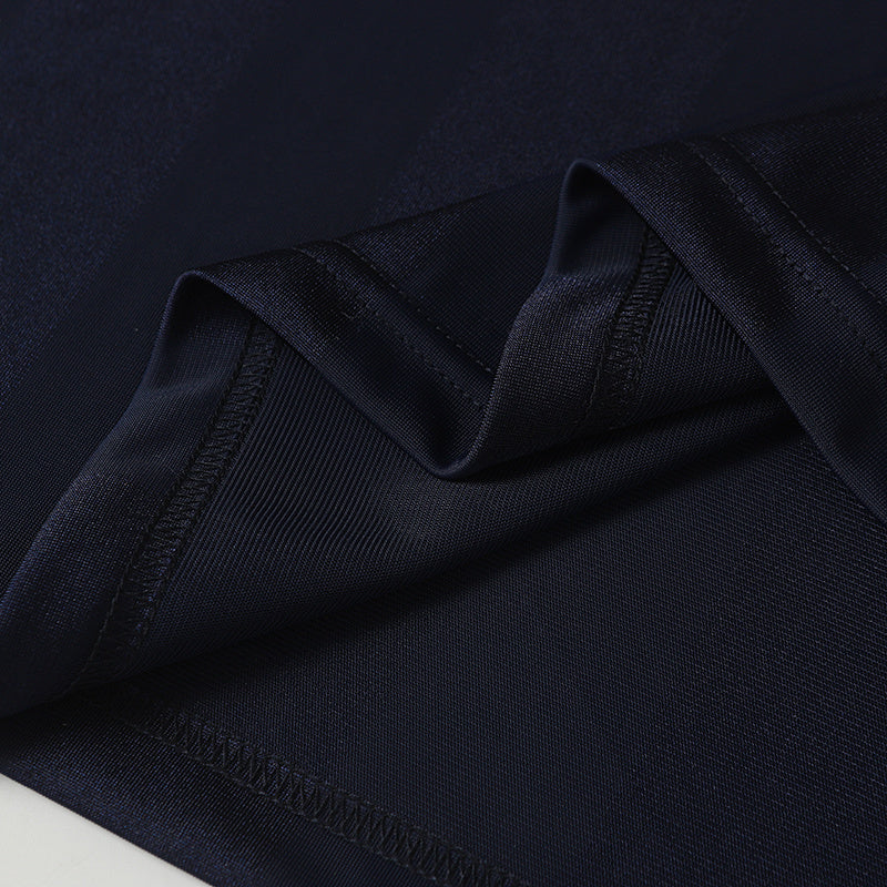 Close-up of navy performance soccer jersey fabric with folded hem and stitched seam detailing