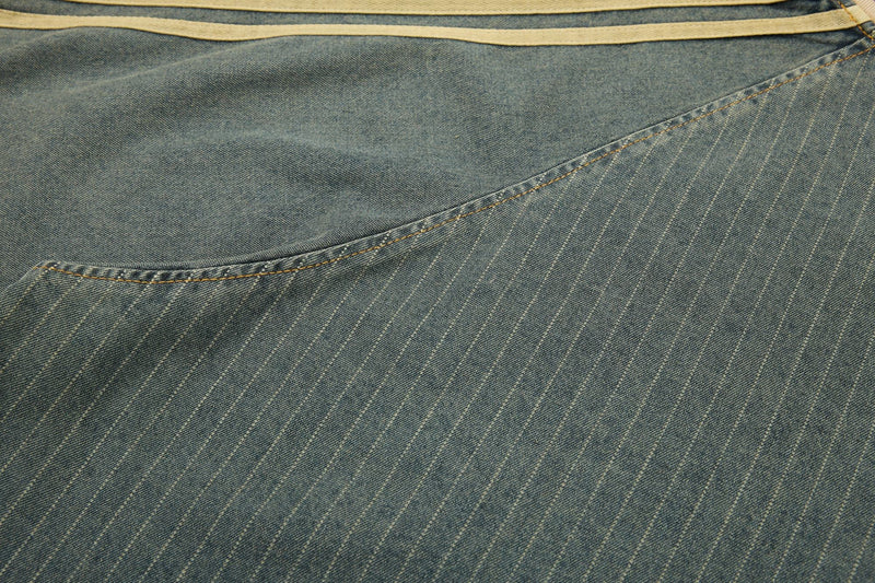 Close-up of blue pinstripe denim fabric with curved seam detail and vintage faded texture
