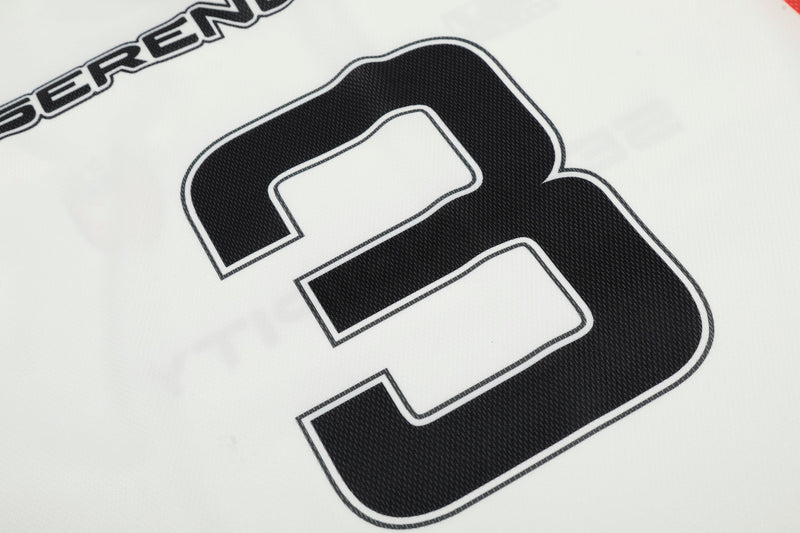 Close-up of black number 3 on the back of a white long-sleeve football jersey