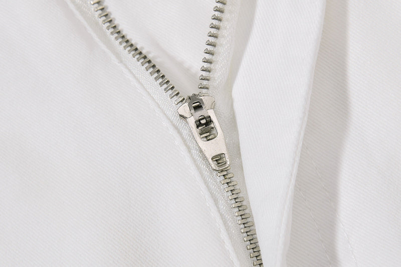Close-up of white shorts zipper detail on side cargo pocket