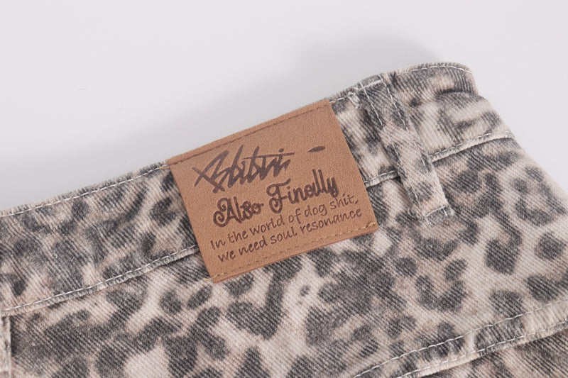 Close-up of brown logo patch on leopard print denim waistband