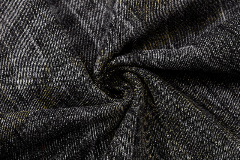 Close-up of twisted black denim fabric with faded vintage wash