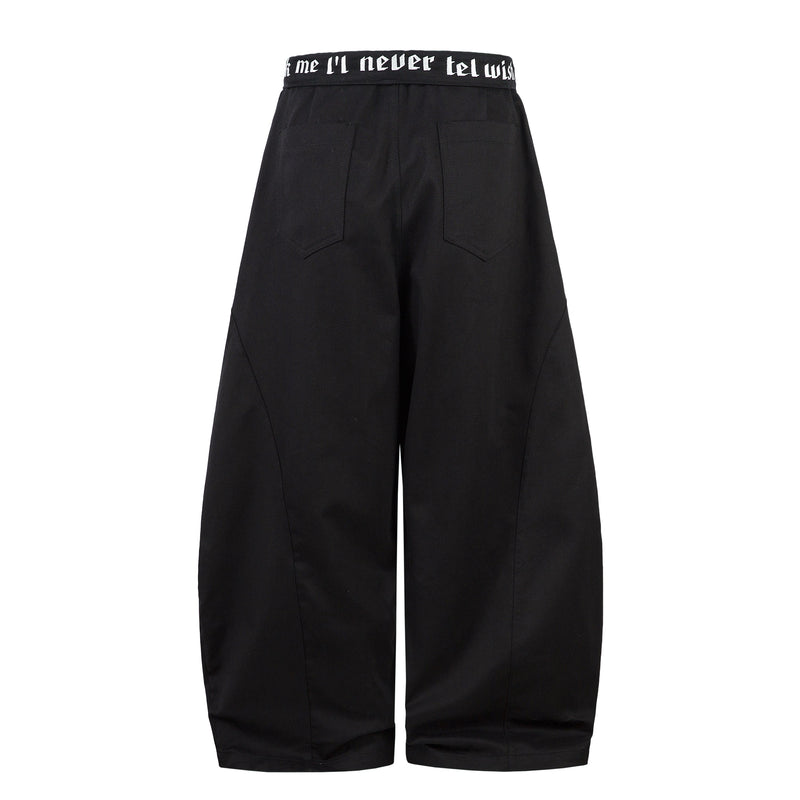 Back view of black barrel-leg pants with printed waistband and two patch pockets