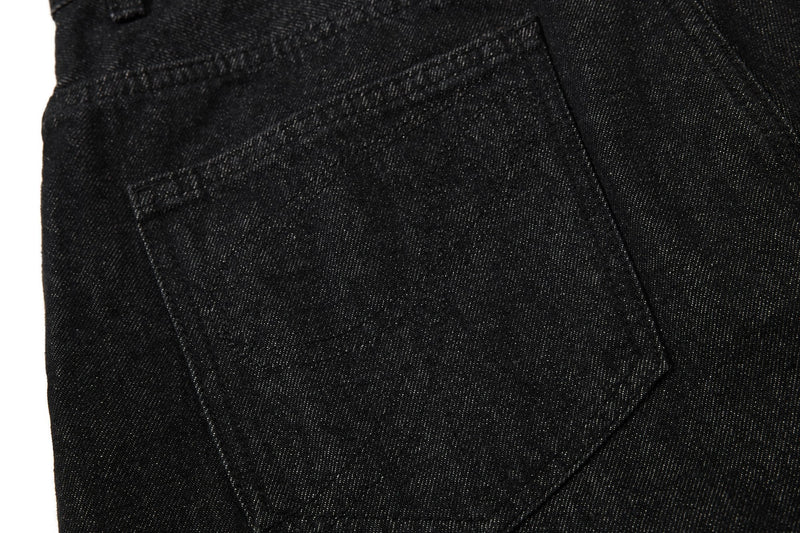 Close-up of back pocket and seam detail on black denim shorts