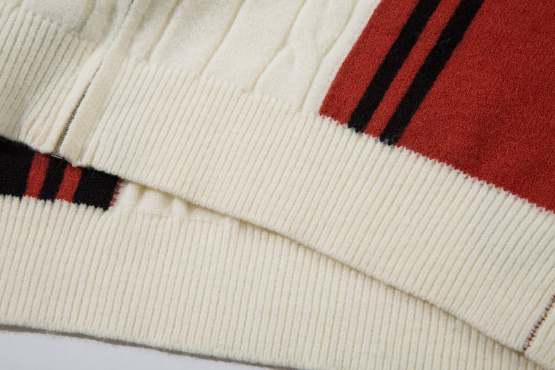 Close-up of hem and sleeve cuff with cream knit and red stripe detail
