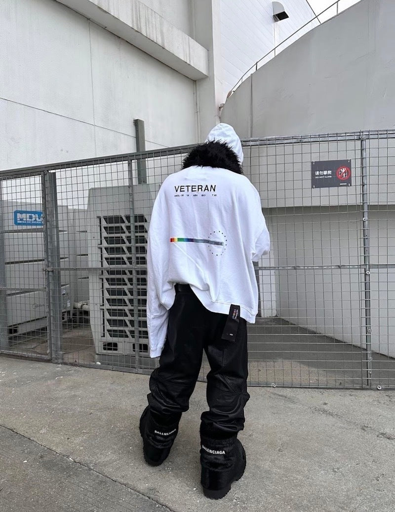 Back view of black wide-leg pants worn with oversized white hoodie and boots