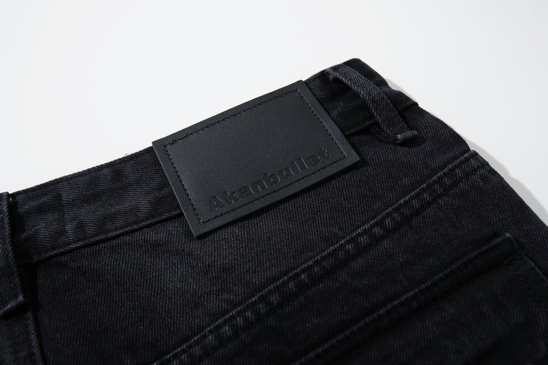 Close-up of black waistband patch embossed with Akanbullat