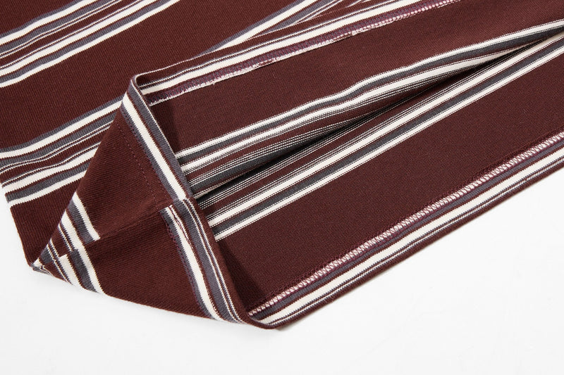 Folded brown vintage stripe rugby polo shirt with white and gray varsity-style stripes on a clean white background