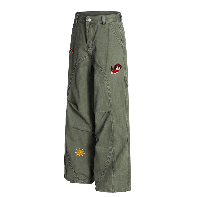 Olive green wide-leg pants with rainbow, dog, sun and other embroidered patches, angled front view