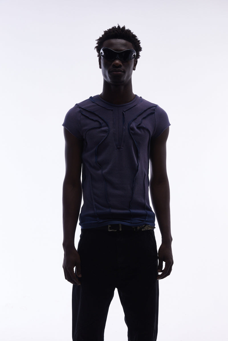 Model wearing a navy sculpted cotton tee with raw seam detailing and a fitted avant-garde streetwear silhouette
