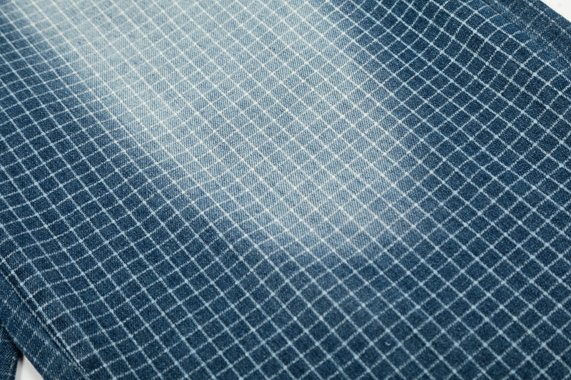 Macro view of blue grid denim fabric with faded wash pattern