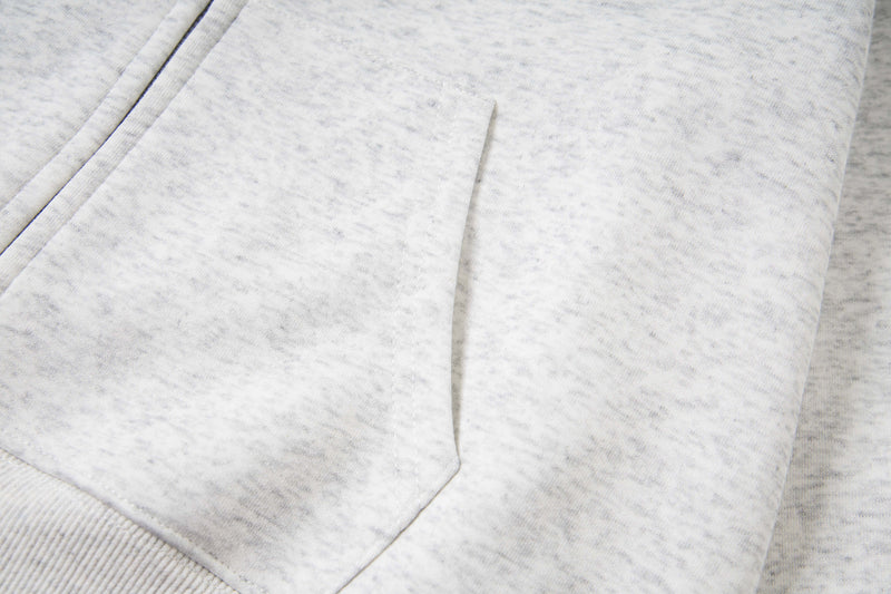 Close-up of white hoodie front pocket on heathered fabric
