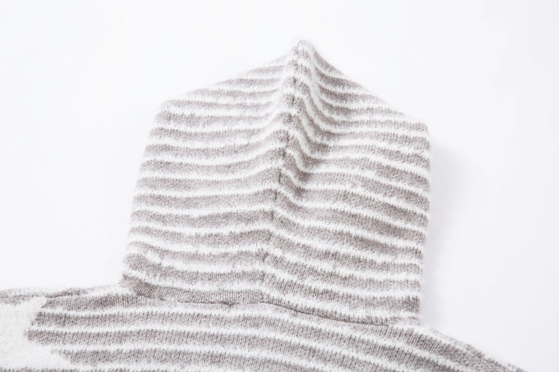 Close-up of the gray striped knit hood and shoulder area with faux fur trim