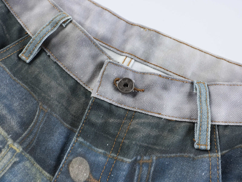Close-up of gray waistband button and belt loop on layered fade denim jeans