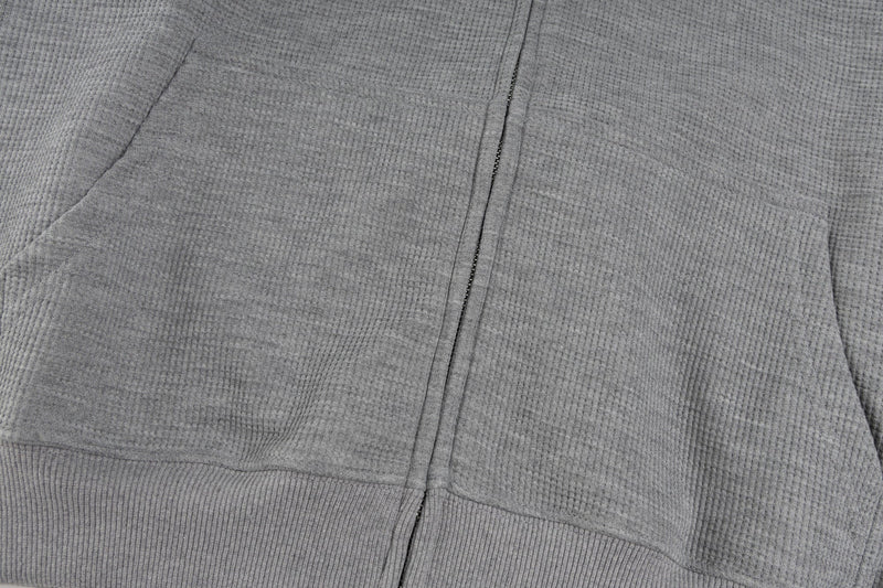 Close-up of gray hoodie front pockets and zipper seam