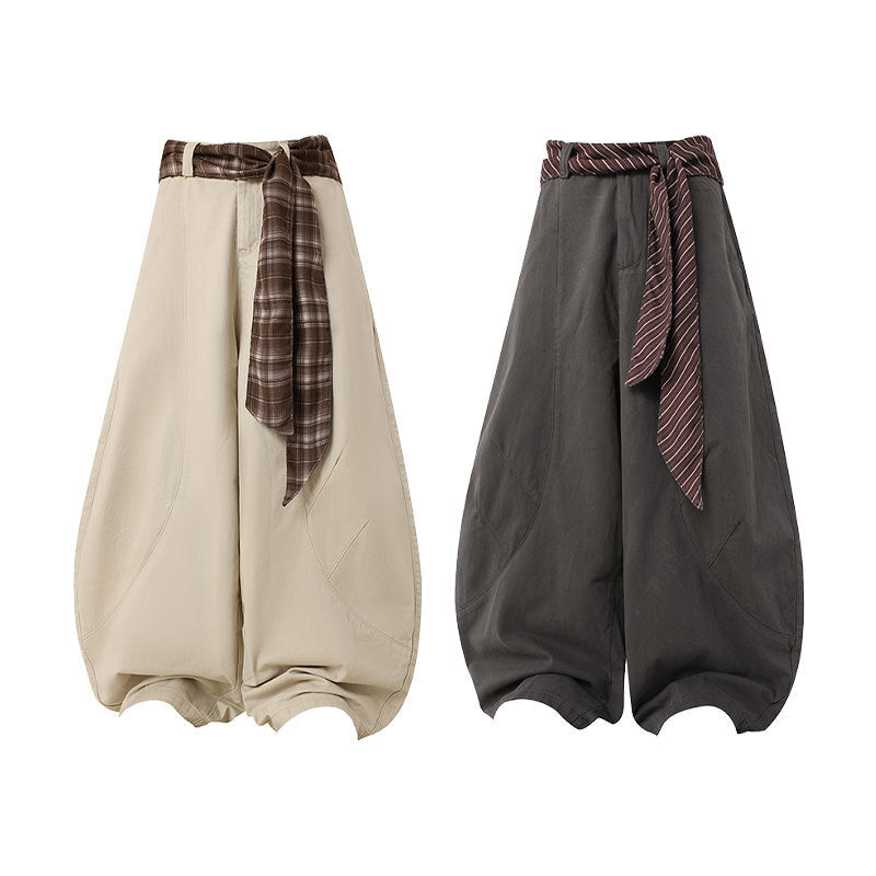 Beige wide-leg barrel pants with brown plaid scarf belt and gathered sculptural hem, front view
