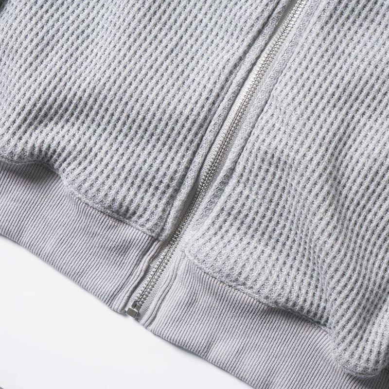 Close-up of the hoodie hem and zipper with ribbed cuff detail