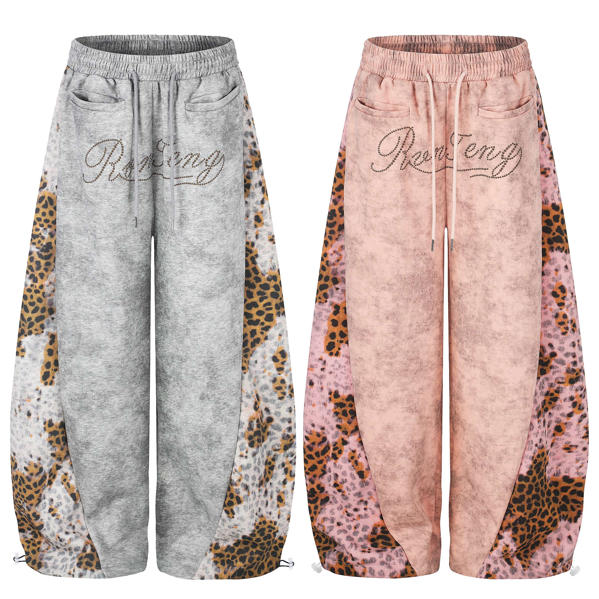Pink vintage-washed wide-leg sweatpants with leopard side panels and rhinestone script logo on white background