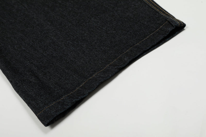 Close-up of the hemmed leg opening on black denim pants