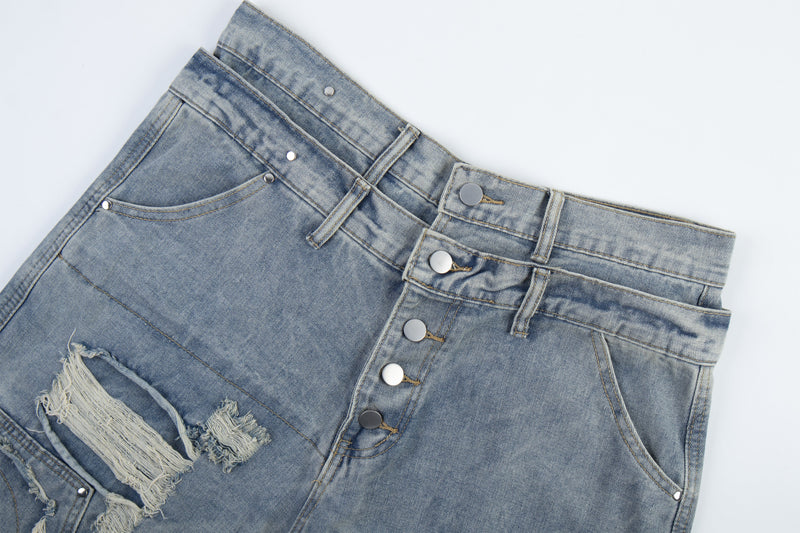 Flat lay of light blue distressed denim waistband with button fly and front pockets