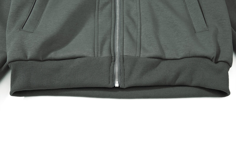 Close-up of lower hem and front zipper on dark green hoodie