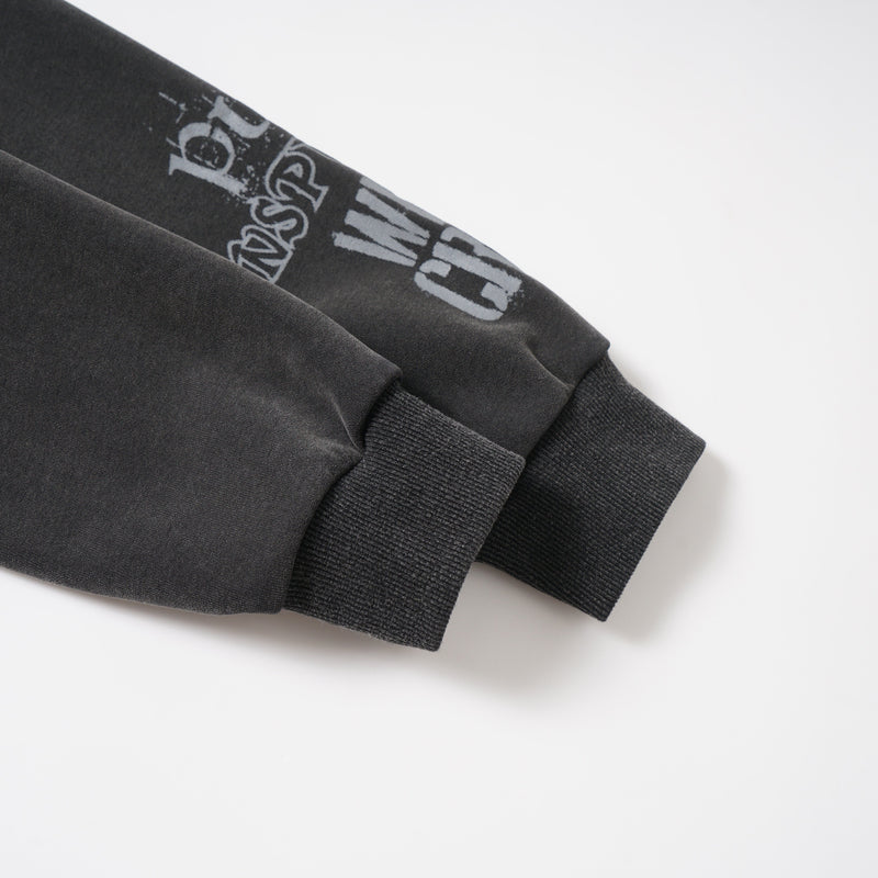 Close-up of sleeve cuff and printed black-and-gray graphic on washed hoodie