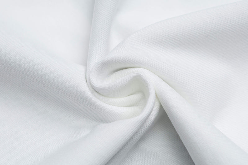 Close-up of white fabric with soft folded texture, showing a clean blank retro graphic tee material background