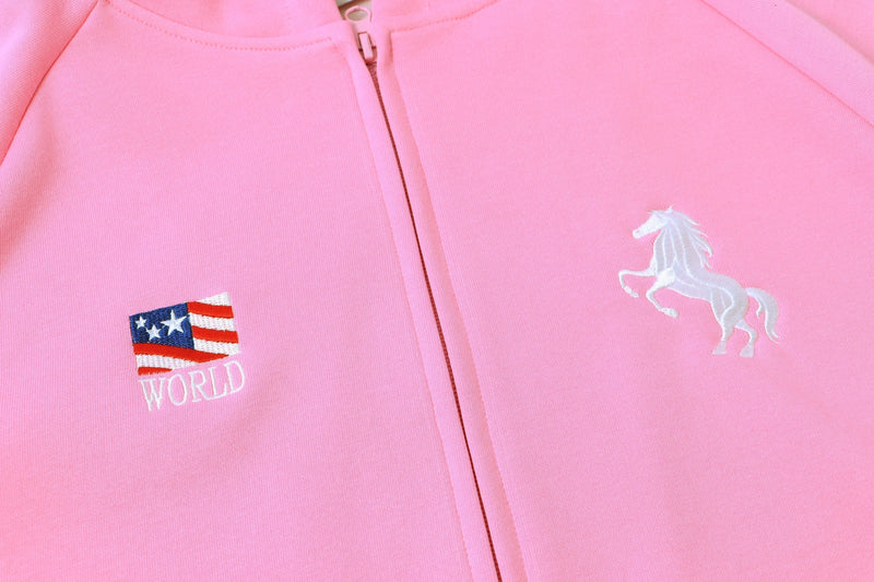Front of pastel pink zip hoodie with unicorn embroidery and small World patch