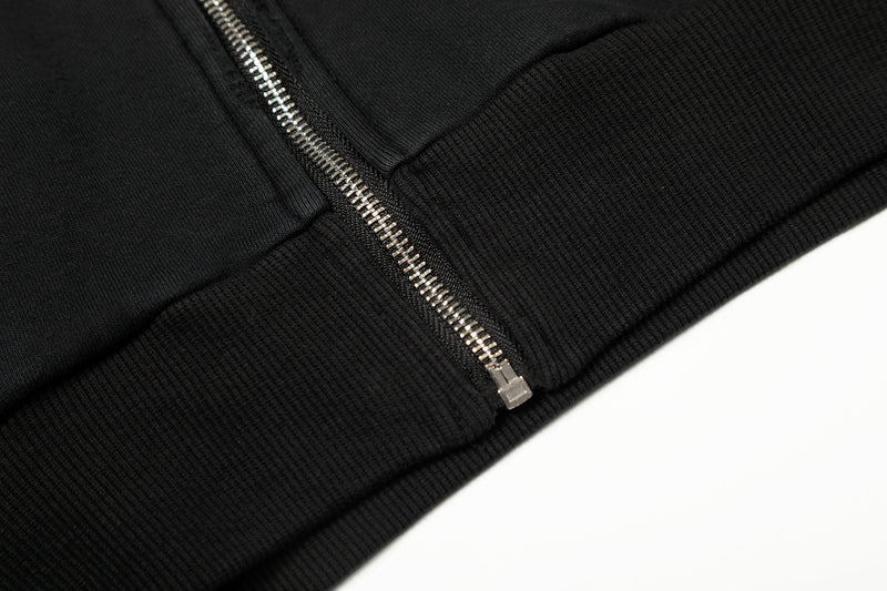 Close-up of black hoodie hem and silver front zipper