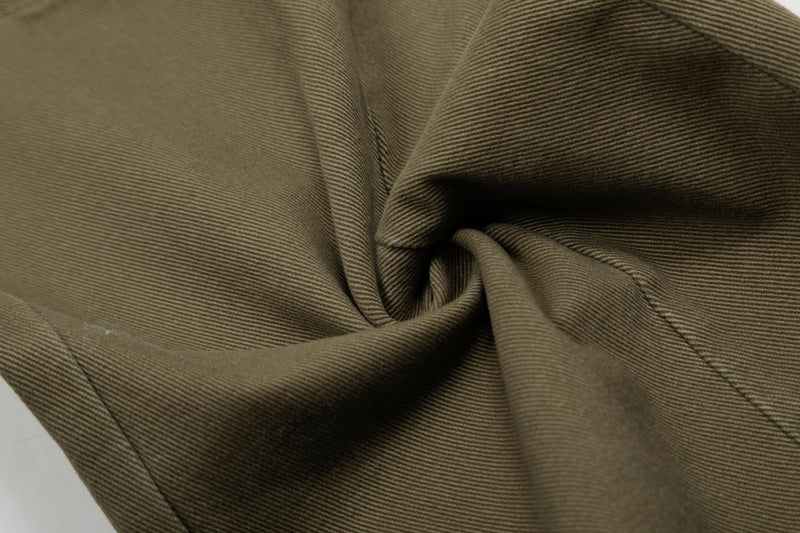 Close-up of olive denim fabric texture and fold detail on cargo jeans