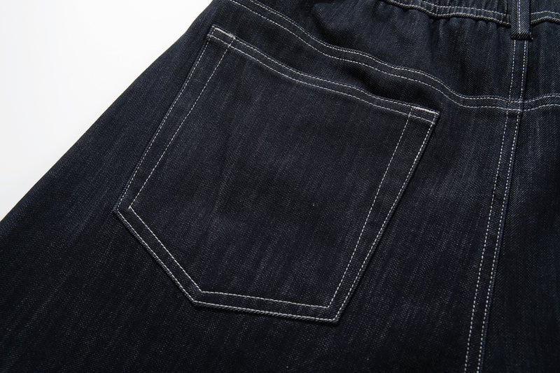 Close-up of the back left patch pocket on dark denim jeans