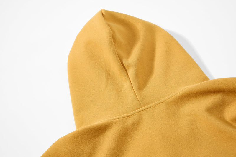 Close-up of mustard yellow hoodie hood and shoulder seam