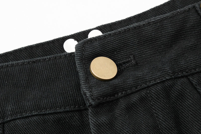 Close-up of black pants waistband snap button and textured twill fabric