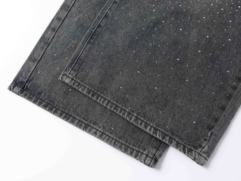 Lower leg and hem detail of black wide-leg jeans with rhinestone speckles