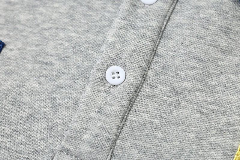 Close-up of white button and center seam on gray sweatshirt