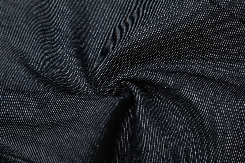 Close-up of dark wash denim fabric texture and seam detail