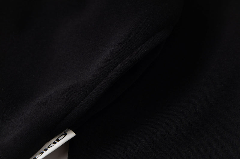 Close-up of black hoodie fabric and small Battlekid side tag near the hem