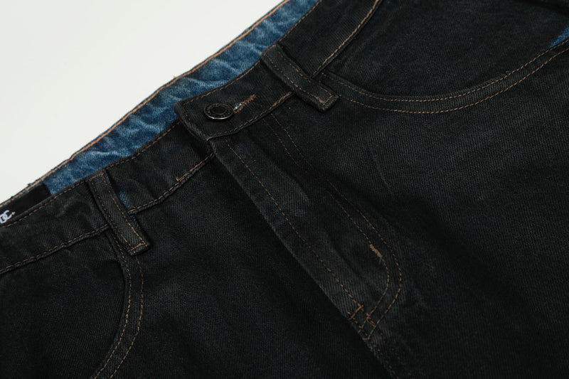 Close-up of black denim front waistband, button closure, belt loop and curved pocket seam