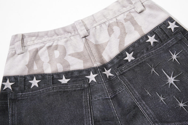 Close-up of waistband and back pockets showing layered black and light denim with stars