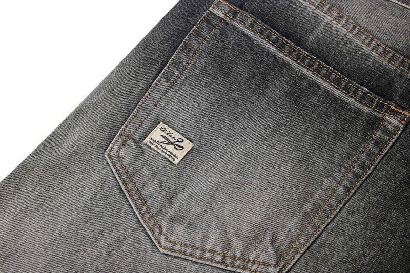 Close-up of back pocket on light faded denim jeans with small stitched tag