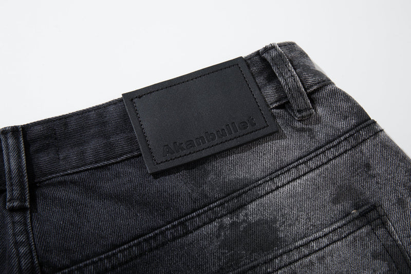 Close-up of black waistband patch label on dark washed jeans with smoky gray fading